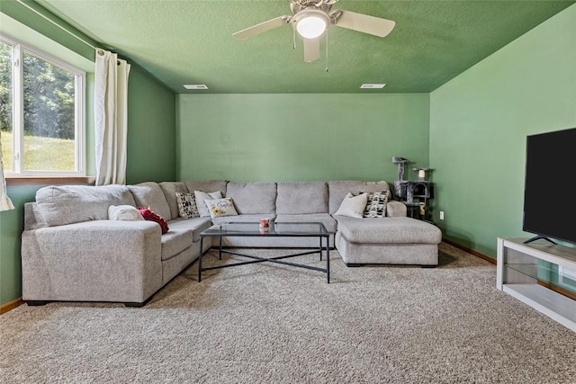 carpeted living room with a textured ceiling and ceiling fan