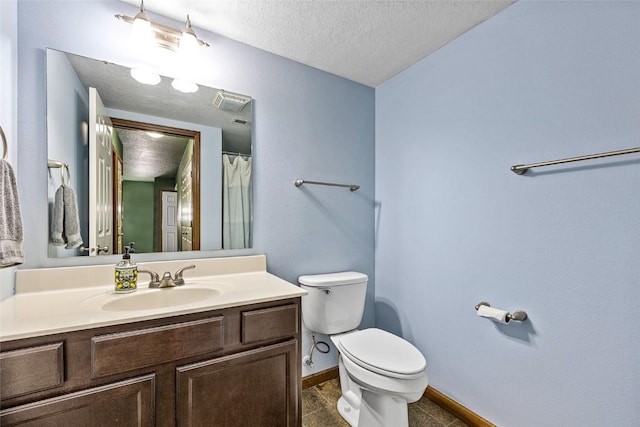 bathroom with tile patterned flooring, vanity, a textured ceiling, and toilet