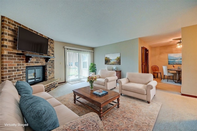 living room featuring a brick fireplace, light colored carpet, and a textured ceiling