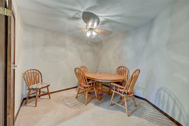 dining room featuring ceiling fan and light carpet