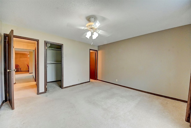 unfurnished bedroom with a textured ceiling, light colored carpet, and ceiling fan