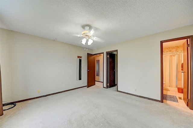 empty room featuring a textured ceiling, light colored carpet, and ceiling fan