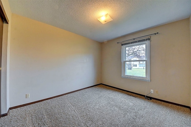 empty room with carpet floors and a textured ceiling