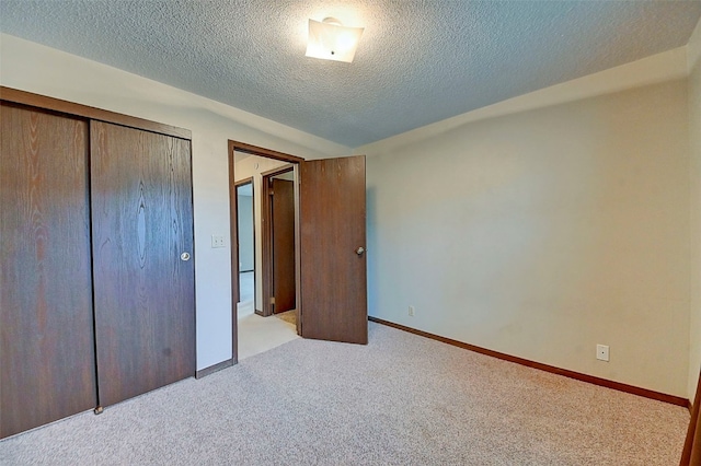 unfurnished bedroom featuring light colored carpet, lofted ceiling, a closet, and a textured ceiling