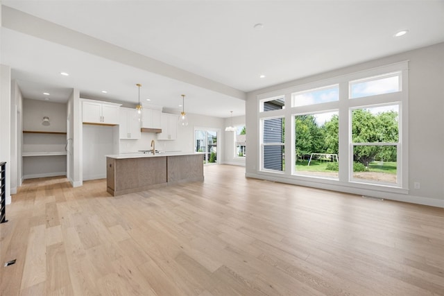 750 Hampshire Dr, Marion, IA 52302 - kitchen featuring an island with sink, open floor plan, light wood-style floors, white cabinetry, and recessed lighting