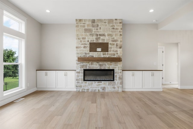 750 Hampshire Dr, Marion, IA 52302 - unfurnished living room with light wood-style flooring and a fireplace