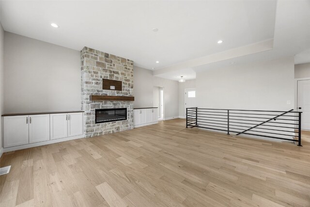 750 Hampshire Dr, Marion, IA 52302 - unfurnished living room with light wood finished floors, recessed lighting, and a stone fireplace