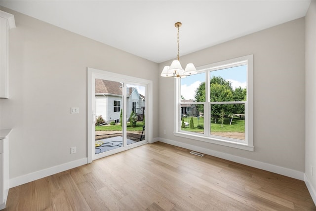 750 Hampshire Dr, Marion, IA 52302 - unfurnished dining area with a chandelier and light wood-type flooring