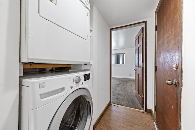 laundry room with stacked washer and dryer and hardwood / wood-style flooring