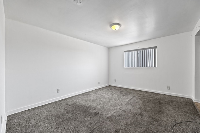 spare room with dark colored carpet