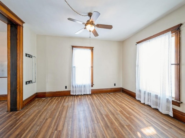 spare room with ceiling fan, baseboards, and wood finished floors