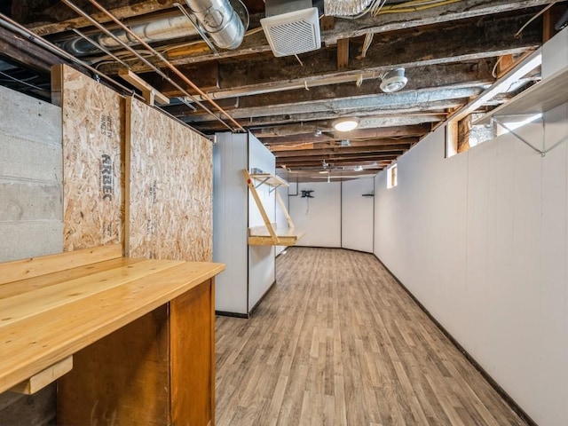 basement with visible vents and wood finished floors