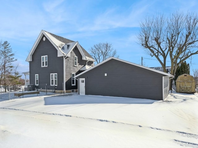 snow covered property with an outdoor structure