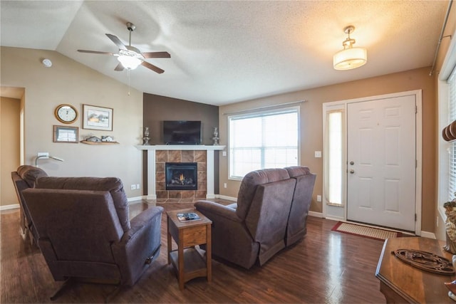 living room with dark hardwood / wood-style flooring, a fireplace, vaulted ceiling, and a textured ceiling