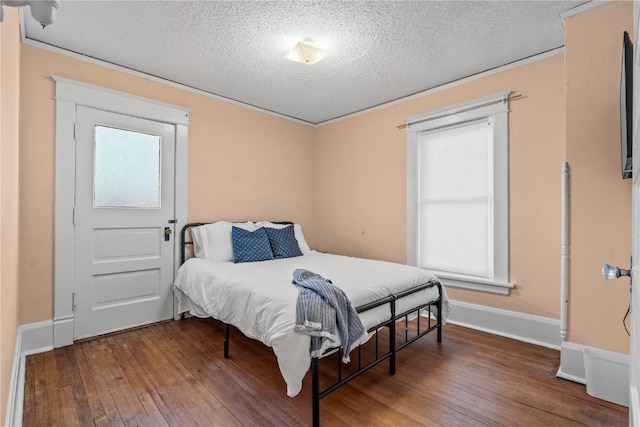 bedroom with wood-type flooring, multiple windows, and a textured ceiling