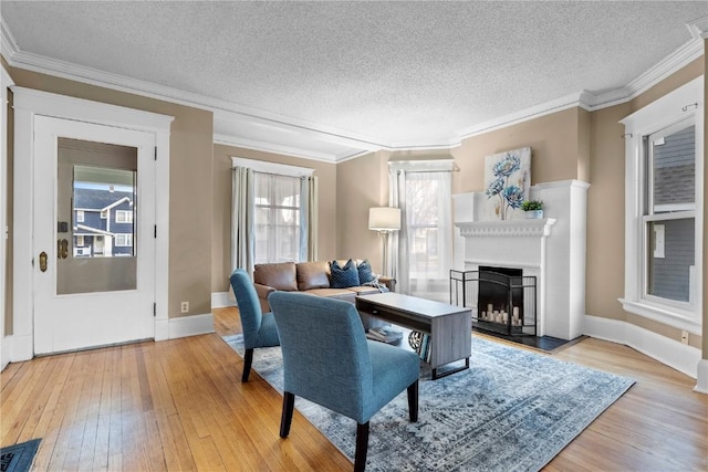 living room featuring ornamental molding, hardwood / wood-style floors, and a textured ceiling