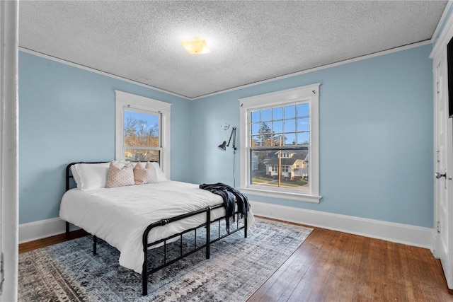 bedroom featuring wood-type flooring, multiple windows, and a textured ceiling