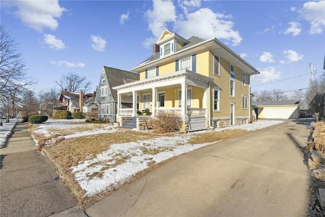 view of front of home with a garage, an outbuilding, and covered porch