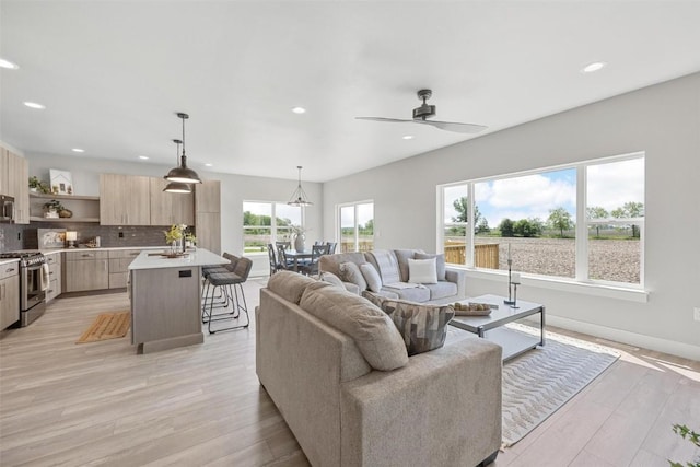 living room featuring ceiling fan and light wood-type flooring