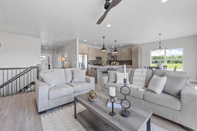 living room featuring light hardwood / wood-style flooring and ceiling fan