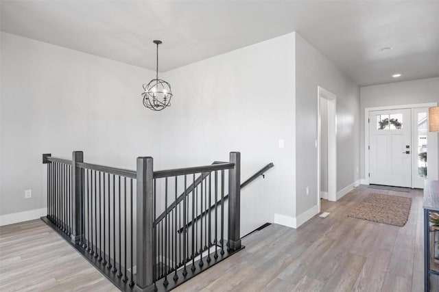 foyer with an inviting chandelier and light hardwood / wood-style flooring