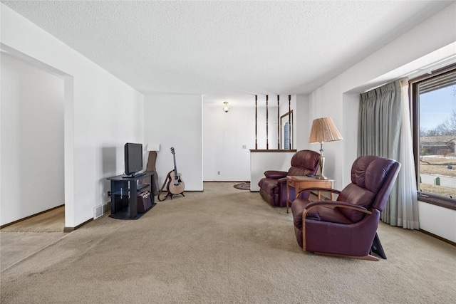 living area with light carpet and a textured ceiling