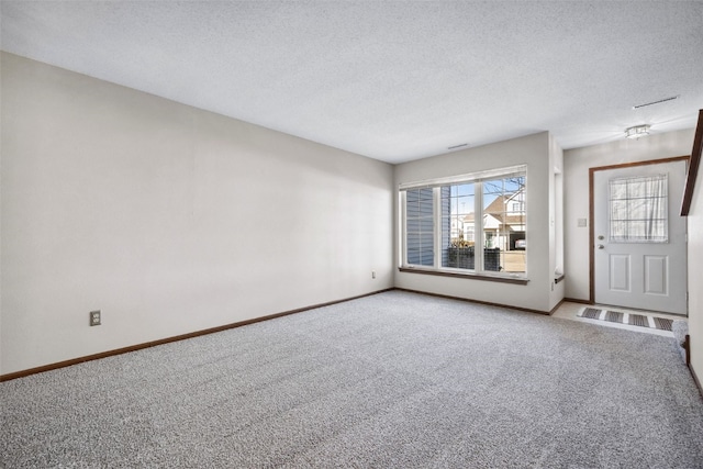 interior space featuring carpet flooring and a textured ceiling