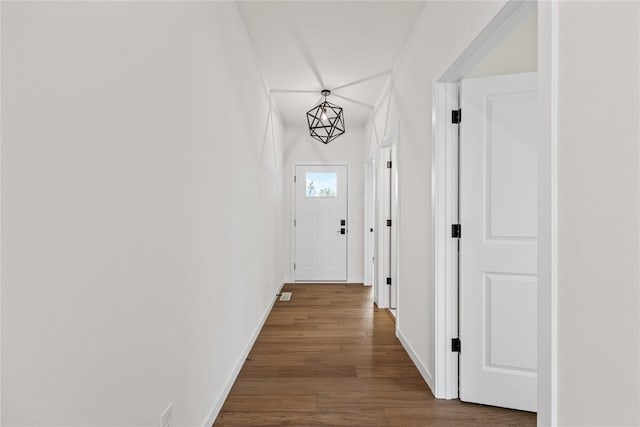 hall with a notable chandelier and wood-type flooring