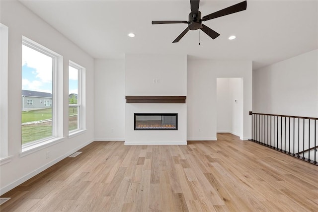 unfurnished living room featuring ceiling fan and light hardwood / wood-style flooring