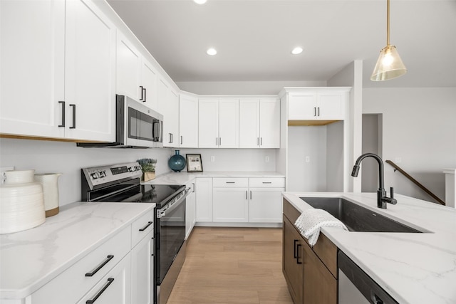 8908 Norway Dr NE, Cedar Rapids, IA 52402 - kitchen with stainless steel appliances, a sink, white cabinetry, hanging light fixtures, and recessed lighting