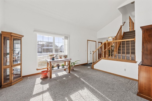 carpeted dining area with high vaulted ceiling