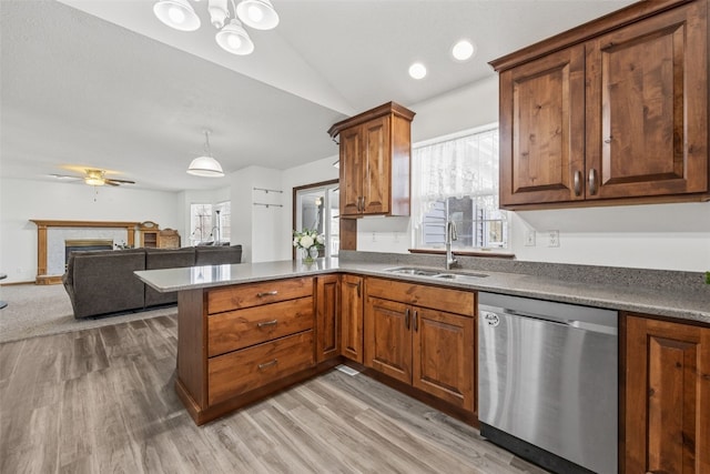 kitchen with vaulted ceiling, light hardwood / wood-style floors, dishwasher, and sink