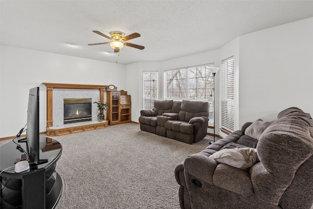 carpeted living room featuring ceiling fan, a high end fireplace, and a textured ceiling