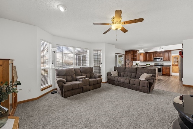 carpeted living room with ceiling fan and a textured ceiling