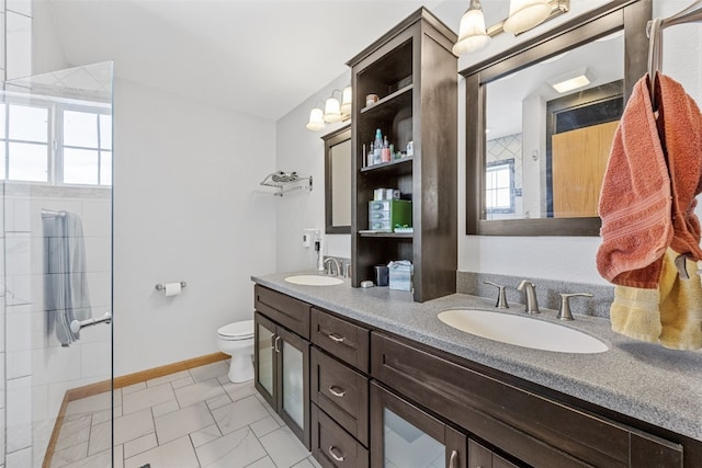 bathroom featuring vanity, toilet, and a tile shower