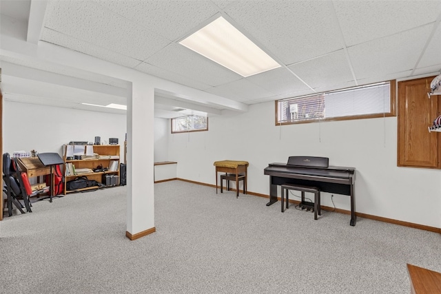 basement with a paneled ceiling and carpet