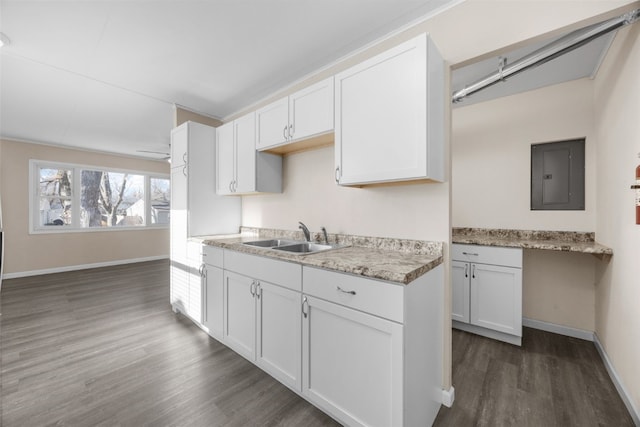 kitchen featuring sink, dark wood-type flooring, electric panel, light stone counters, and white cabinets