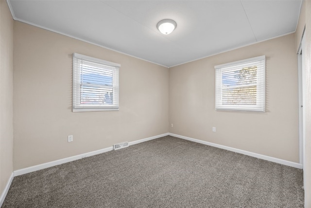 carpeted spare room featuring plenty of natural light