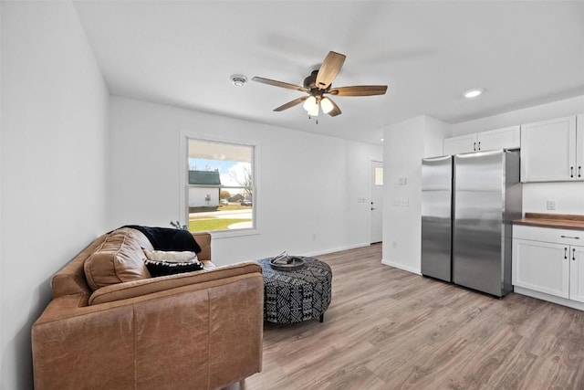 sitting room with ceiling fan and light hardwood / wood-style flooring