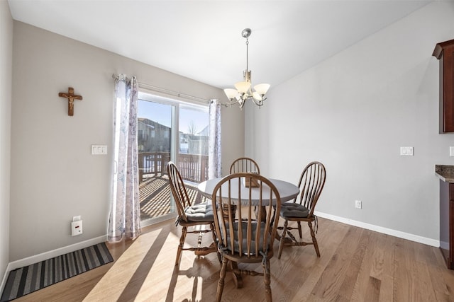 dining space with an inviting chandelier and light hardwood / wood-style floors