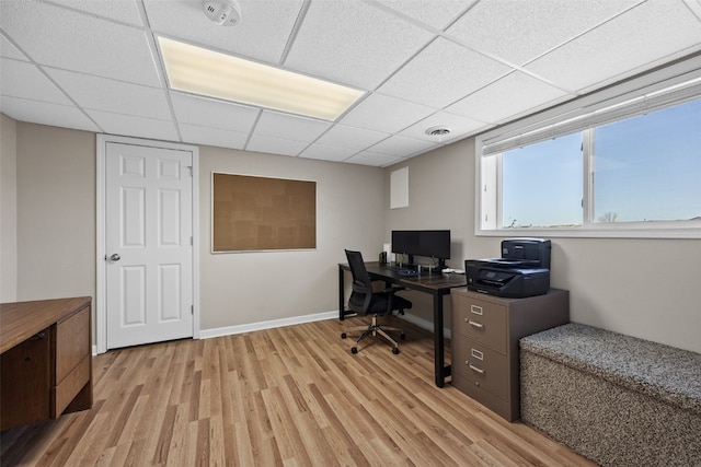 office with light hardwood / wood-style floors and a drop ceiling