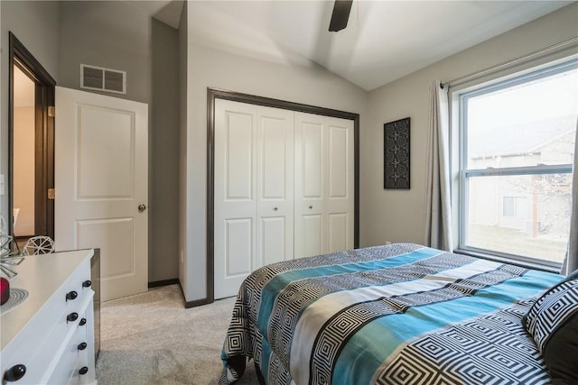 bedroom featuring lofted ceiling, light colored carpet, ceiling fan, and a closet