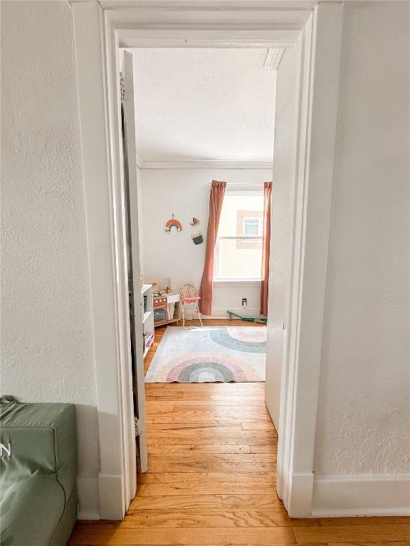 corridor with crown molding and hardwood / wood-style flooring