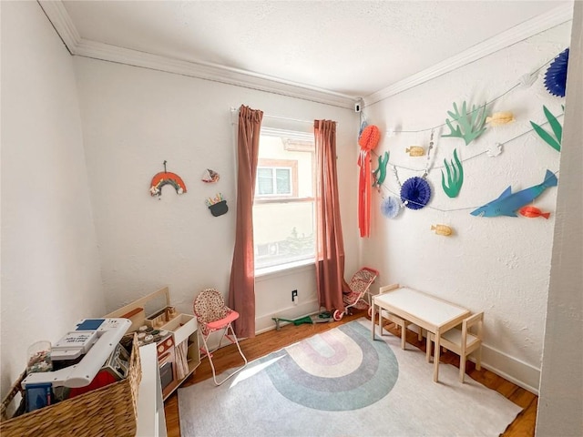 rec room with ornamental molding and wood-type flooring