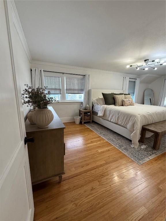 bedroom with crown molding and light wood-type flooring