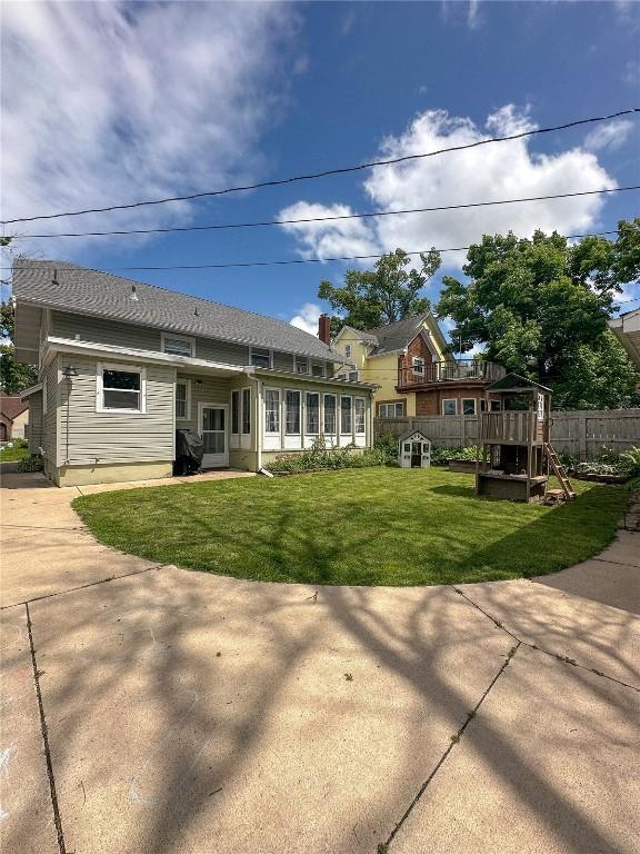 back of house featuring a yard and a sunroom