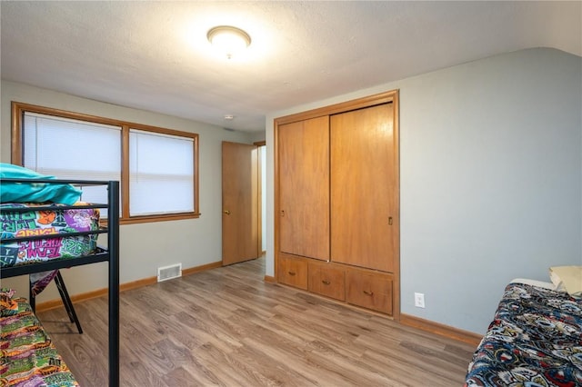 bedroom featuring a textured ceiling and light wood-type flooring