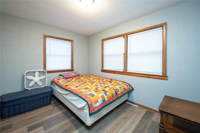 bedroom featuring dark hardwood / wood-style floors and multiple windows