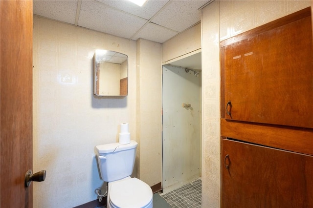 bathroom featuring a shower, a paneled ceiling, and toilet