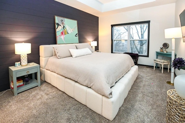 bedroom with carpet floors and wooden walls